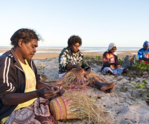 The Wilfred Mob, Weaving on the Beach, Photo: Courtesy of Numbulwar Numburindi Arts.