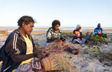 The Wilfred Mob, Weaving on the Beach, Photo: Courtesy of Numbulwar Numburindi Arts.