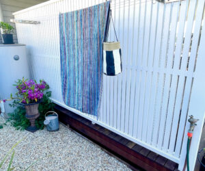 stainless steel brackets and cable mounted onto a timber screen as a clothesline