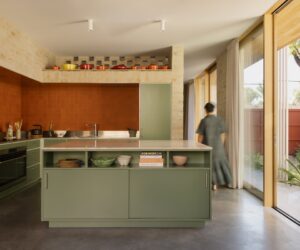 Central kitchen with display shelving for colourful pots and Bennett’s Pottery tiles, photographed for green magazine issue 106: Playful Echoes by Timothy Kaye.