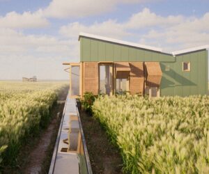 A small prefabricated house elevated above agricultural fields, with rainwater channels leading toward the structure and vegetation surrounding the site.