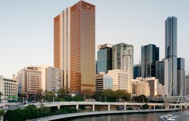 Wide view of the 205 North Quay tower within the Brisbane city skyline beside the river, surrounded by neighbouring commercial buildings.