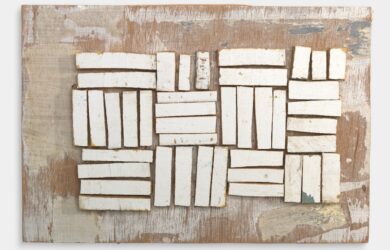 Assemblage of rectangular white-painted wooden fragments arranged in blocks on a weathered timber backing.