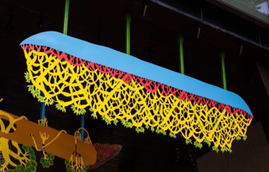 Hanging sculptural metalwork forms suspended beneath a timber ceiling at Barangaroo South.
