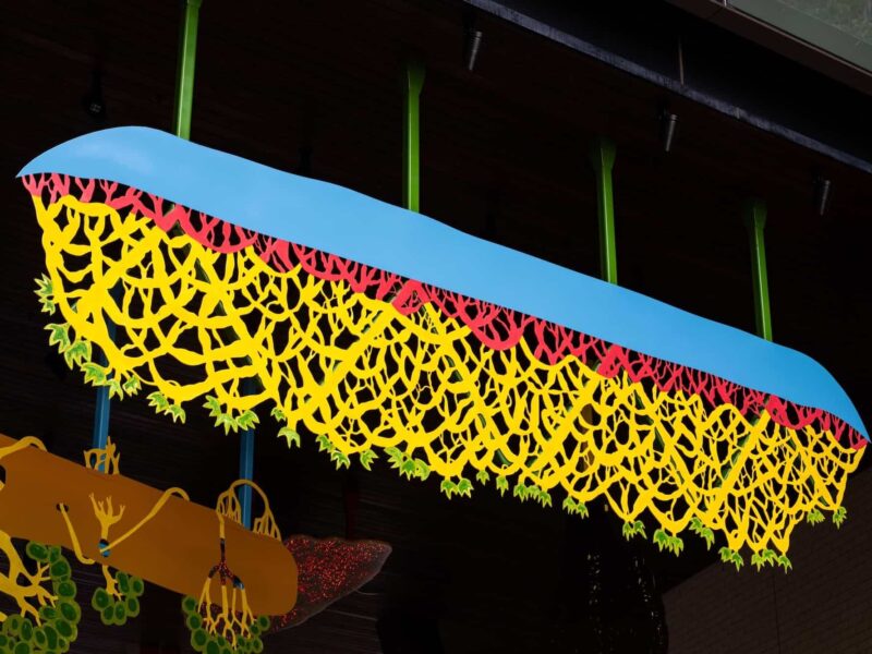 Hanging sculptural metalwork forms suspended beneath a timber ceiling at Barangaroo South.