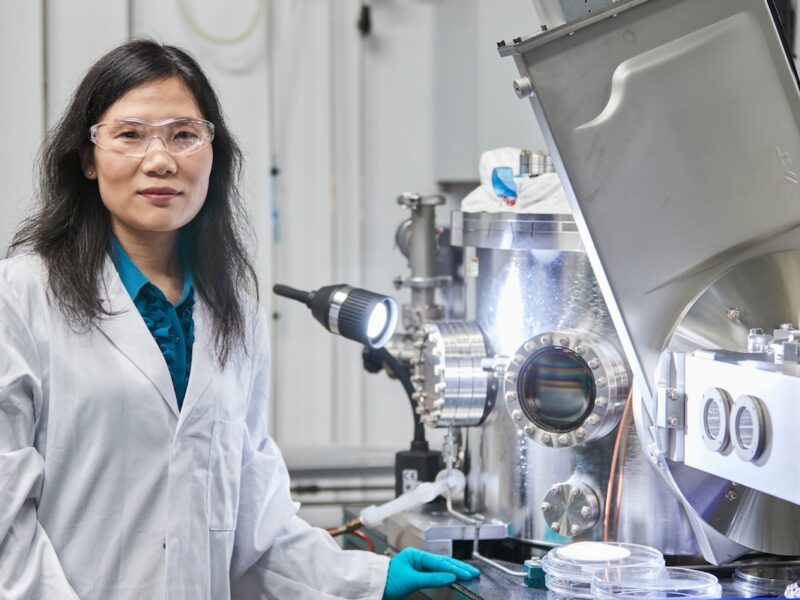 Scientia Professor Xiaojing Hao working in a UNSW laboratory alongside photovoltaic research equipment used in solar cell development.
