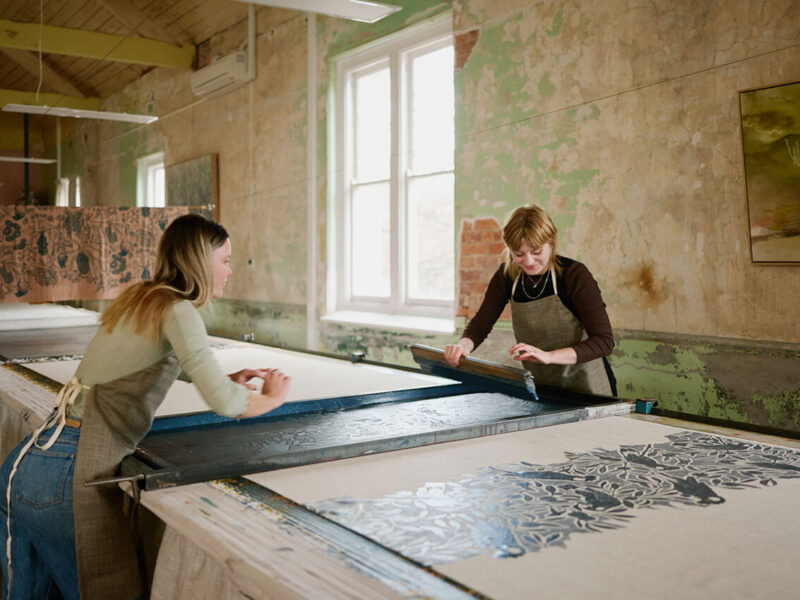 Artists creating large-scale textile prints inside the Ink & Spindle studio during Melbourne Design Week 2026.